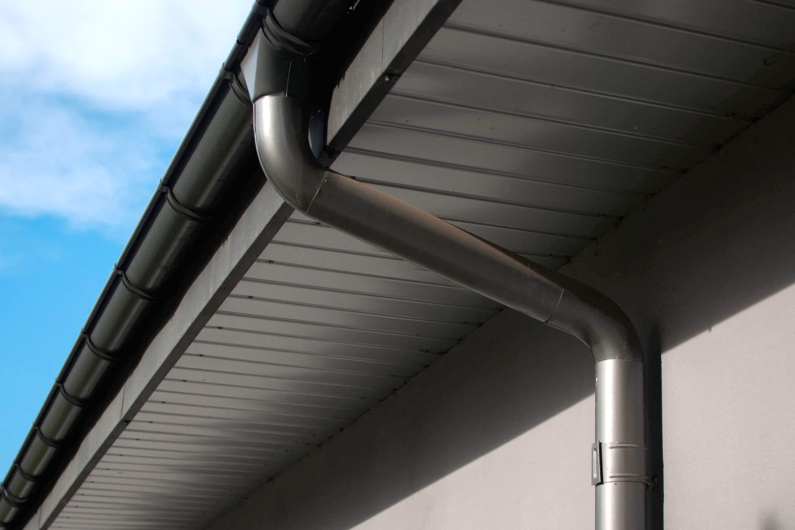 Corrosion-resistant galvanized gutters installed on a commercial building in Stafford